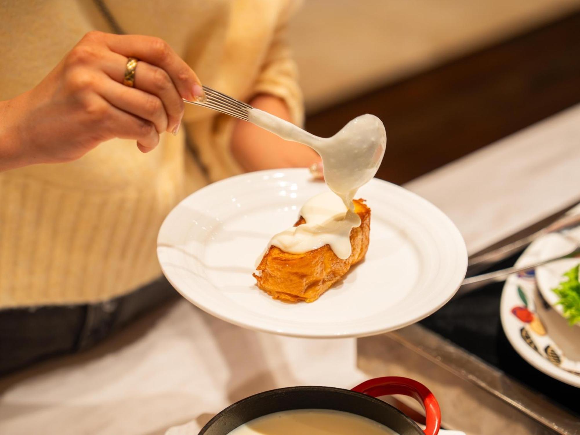 Urayasu Brighton Hotel Tokyo Bay מראה חיצוני תמונה A woman using a spoon to spread mayonnaise on a piece of bread